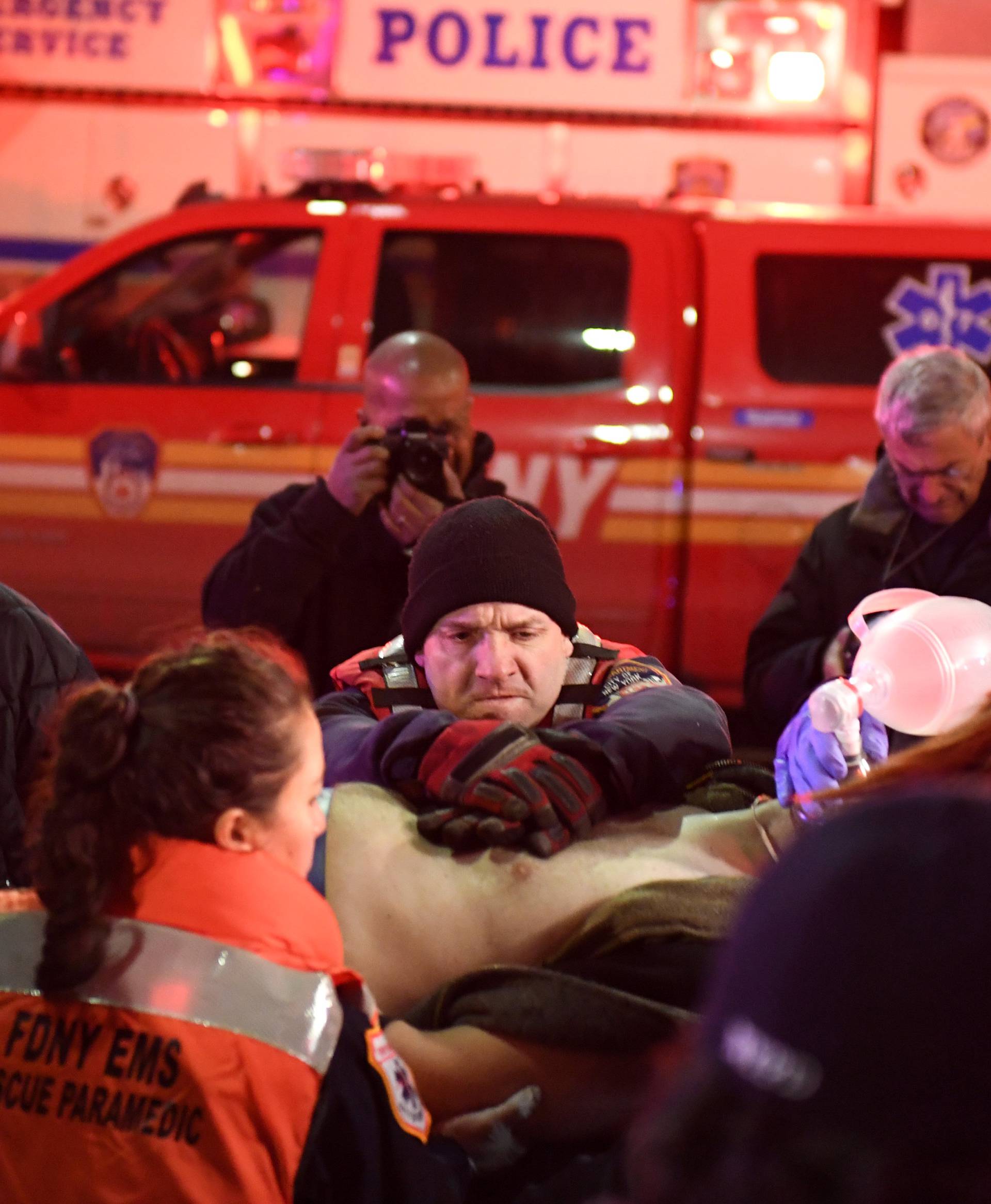 Paramedics and members of the FDNY perform CPR on a victim of a helicopter that crashed into the East River in New York