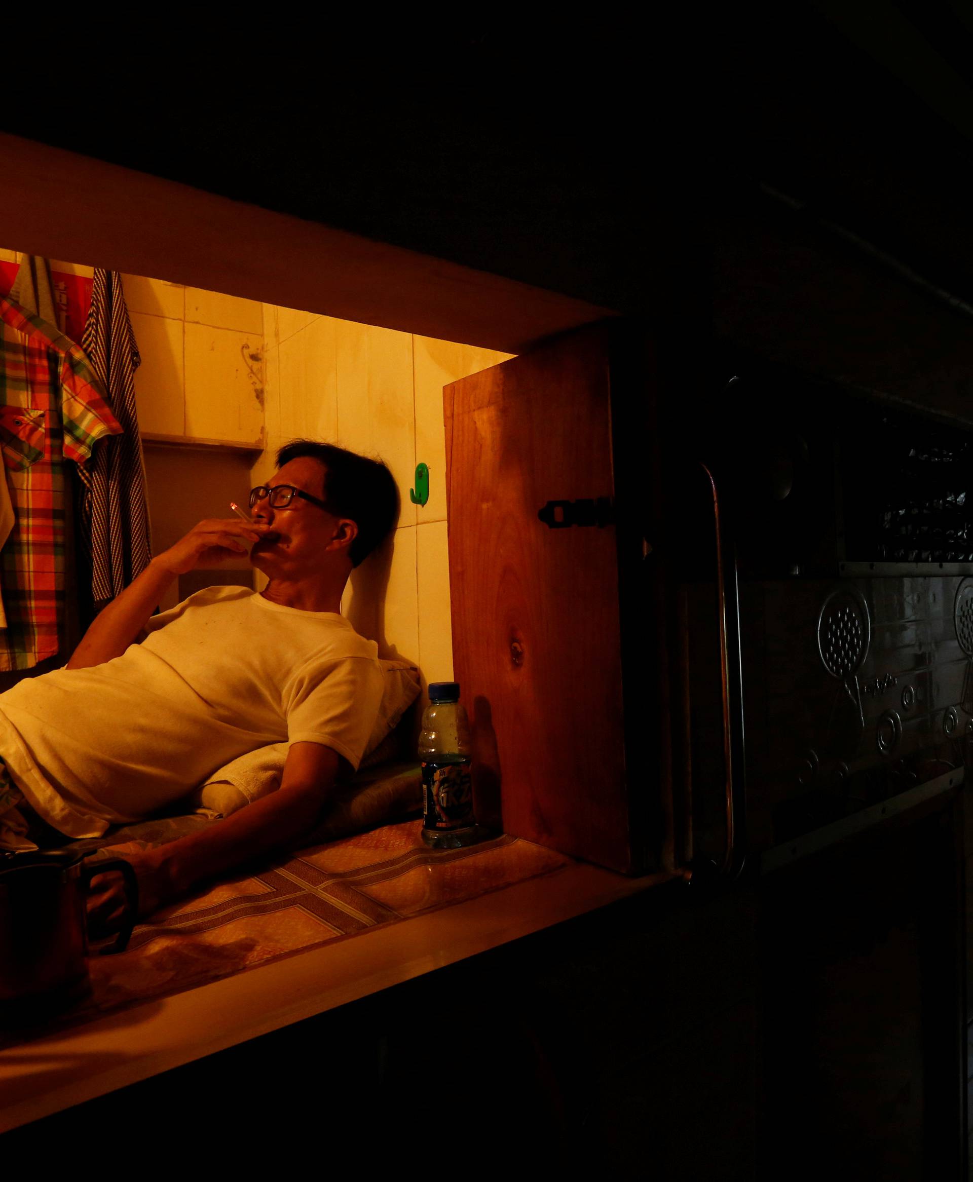 Unemployed Hong Kong resident Simon Wong, 61, smokes inside his 4-by-6-feet partitioned unit, or "coffin unit", with a monthly rent of HK$1,750 ($226) in Hong Kong