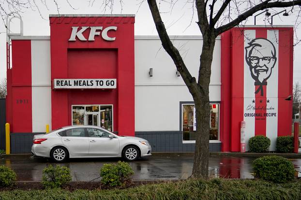 FILE PHOTO: A vehicle waits at the drive-thru window of Kentucky Fried Chicken after a state mandated carry-out only policy went into effect in order to slow the spread of the novel coronavirus (COVID-19) in Louisville