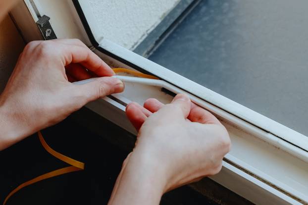 One,Young,Man,Manually,Insulates,A,Window,Frame.
