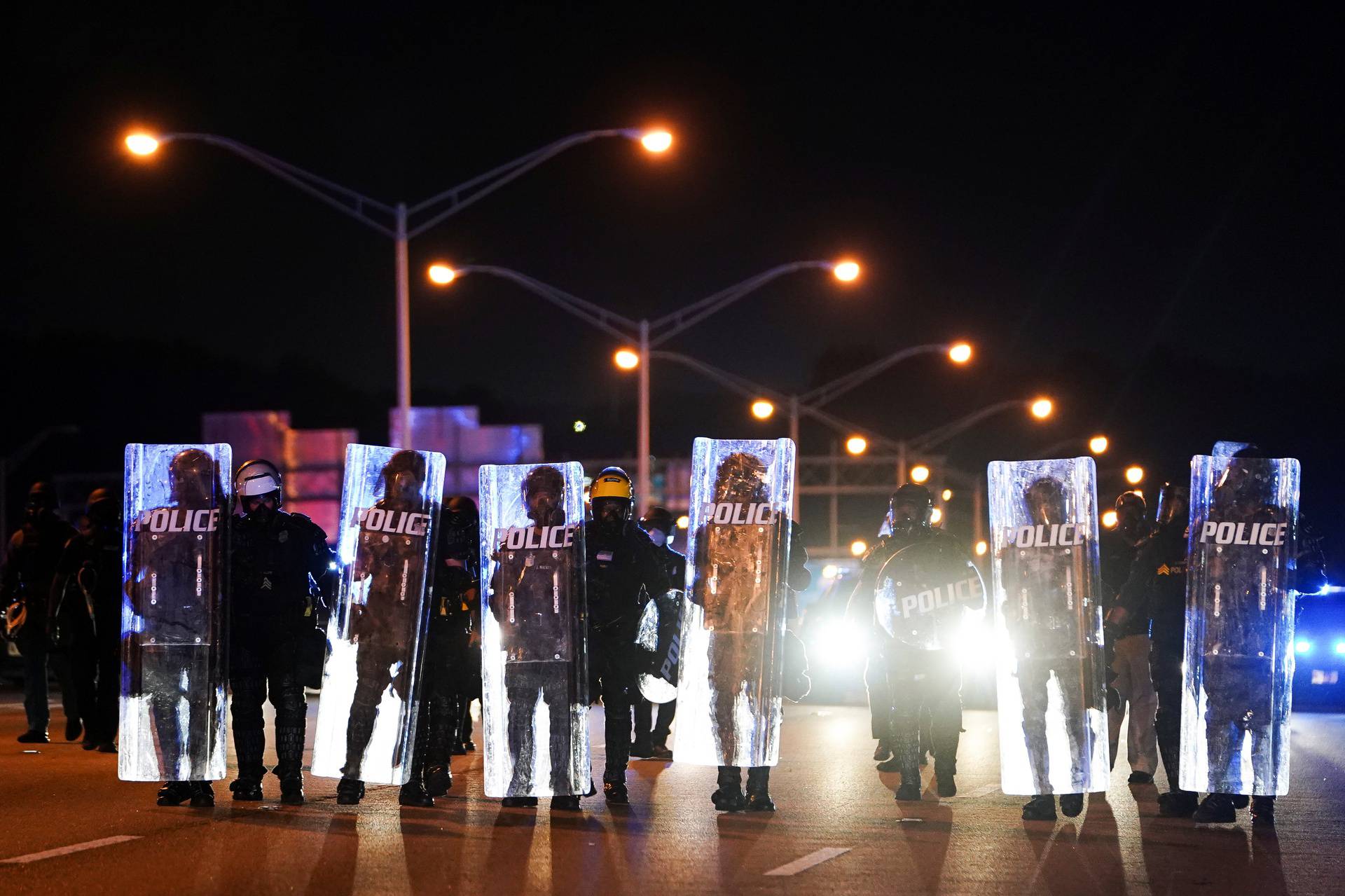 Police with riot shields advance to detain protesters for blocking traffic on a freeway during a rally against racial inequality and the police shooting death of Rayshard Brooks, in Atlanta
