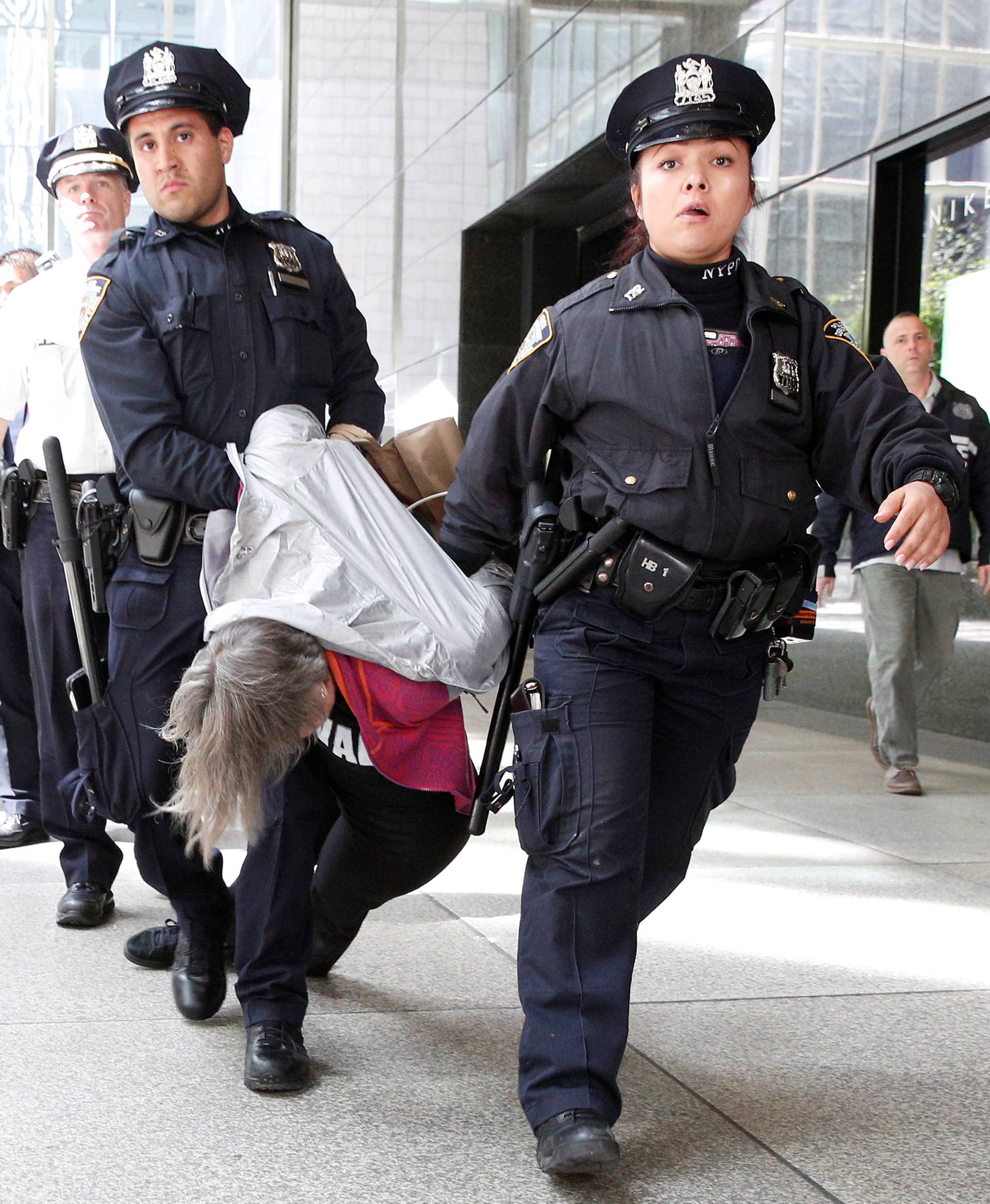 A New York City Police officers (NYPD) carry and escort protestors after making arrests for demonstrating in Trump Tower in New York City