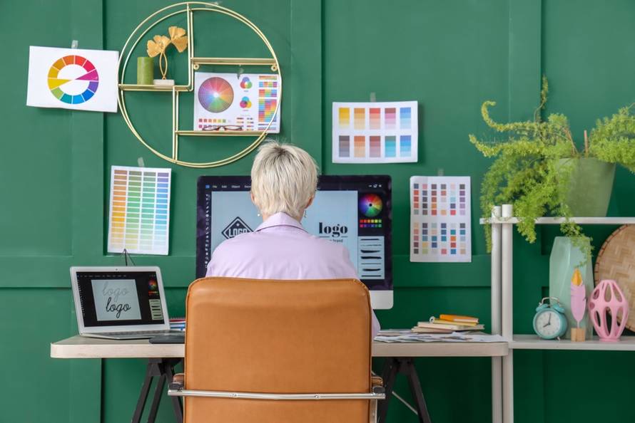 Young,Female,Graphic,Designer,Working,At,Table,In,Office,,Back