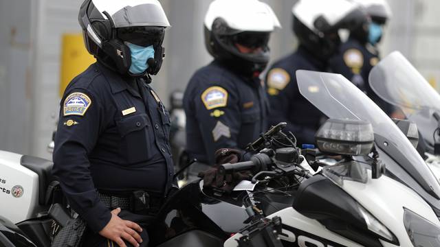 California Highway Patrol police officers wear masks as they watch hotel workers protesting outside airport hotels to demand healthcare coverage extension as the global outbreak of the coronavirus disease (COVID-19) continues, in Los Angeles