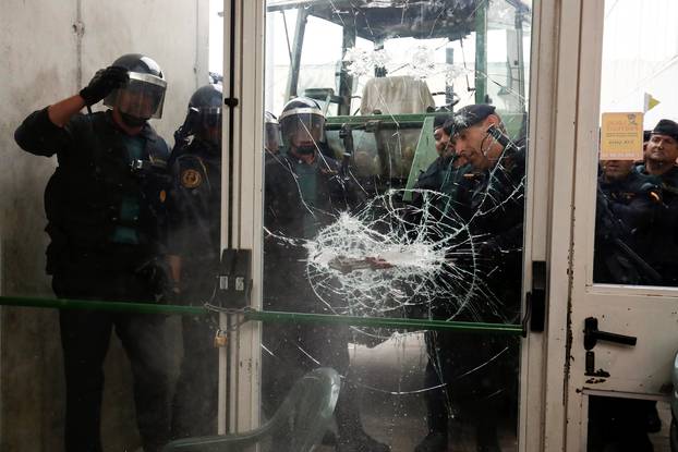 Spanish Civil Guard officers break through a door at a polling station for the banned independence referendum where Catalan President Puigdemont was supposed to vote in Sant Julia de Ramis