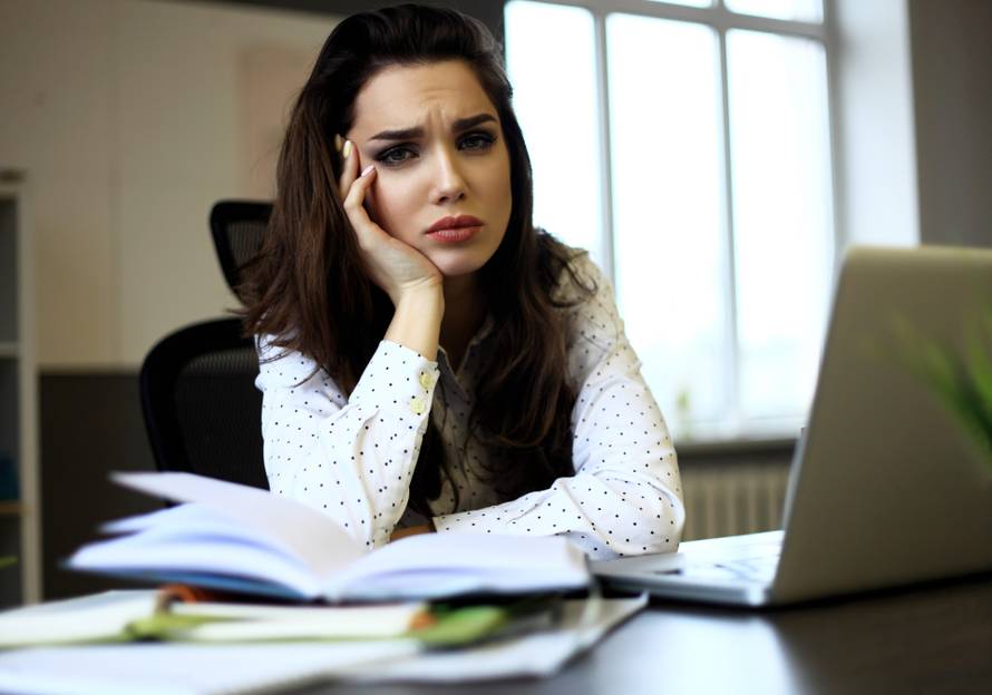 indoor picture of bored and tired woman taking notes