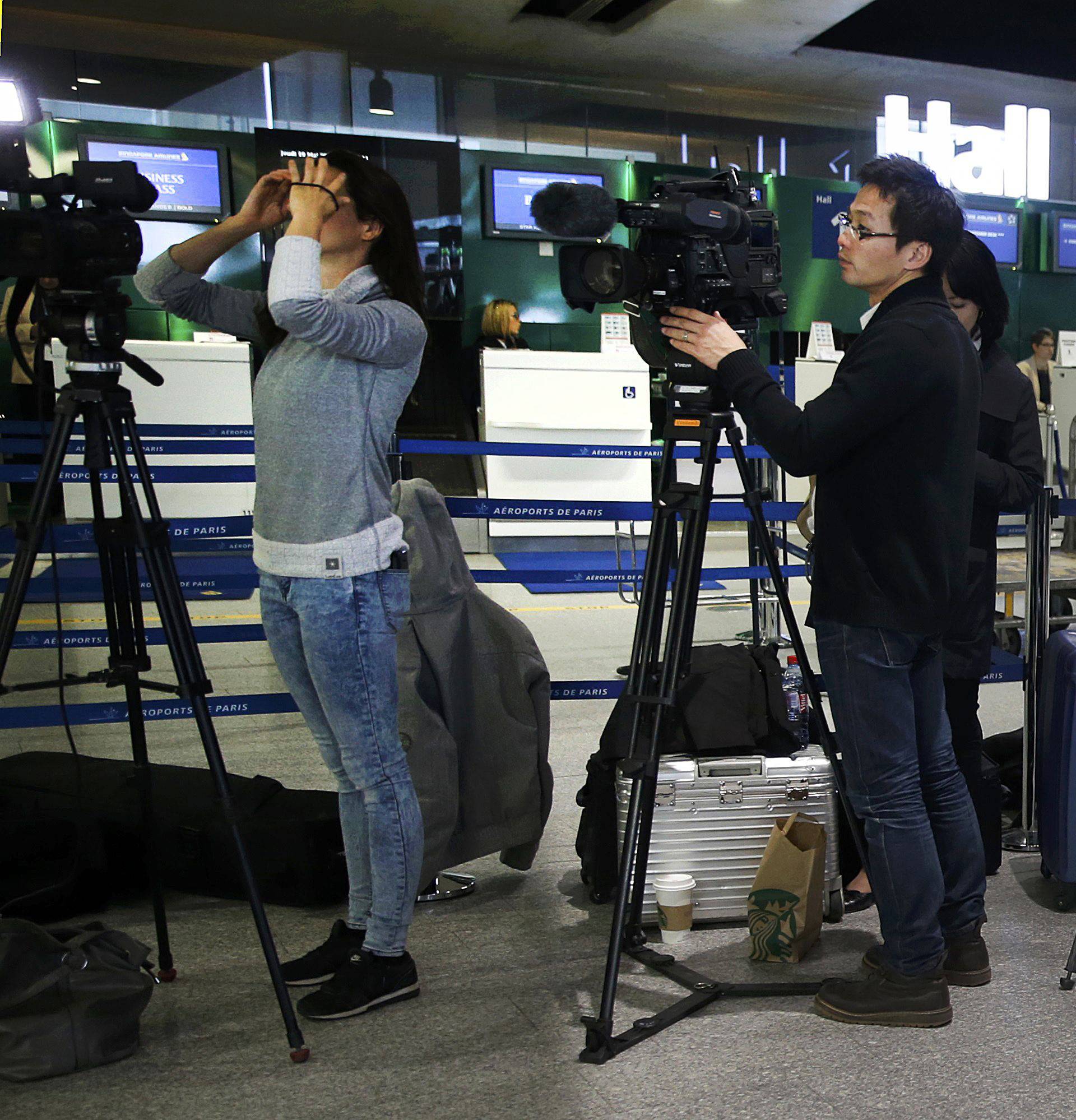 TV crews report near the EgyptAir desk at Charles de Gaulle airport in Paris