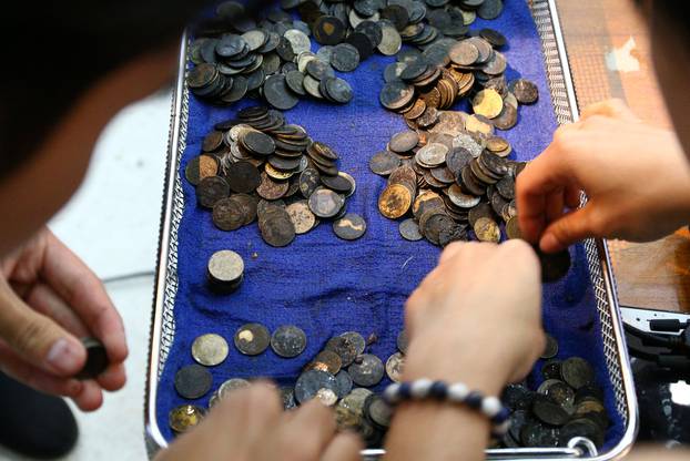 Officers count coins that were removed from the stomach of Omsin, a 25 year old femal green sea turtle, after a surgical operation at the Faculty of Veterinary Science, Chulalongkorn University in Bangkok