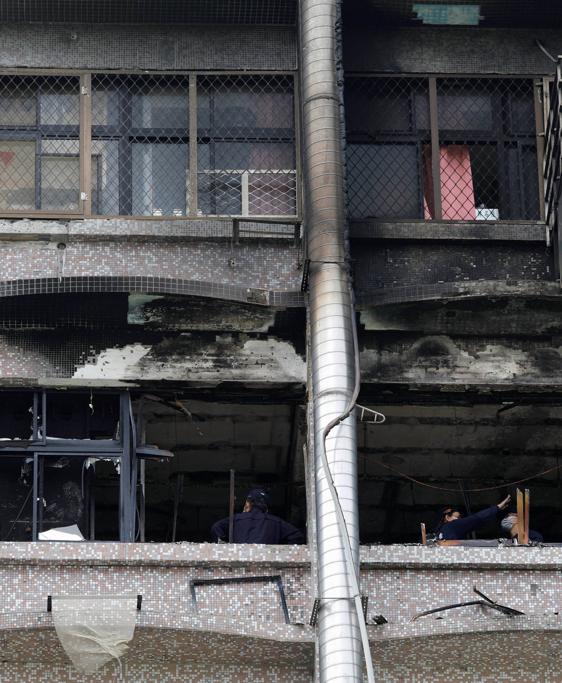 Fire inspectors view damage after a fire broke out at the Taipei Hospital, causing multiple deaths, in New Taipei City
