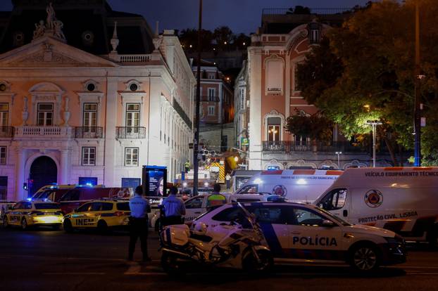 First responders work at the site of a funicular accident in Lisbon