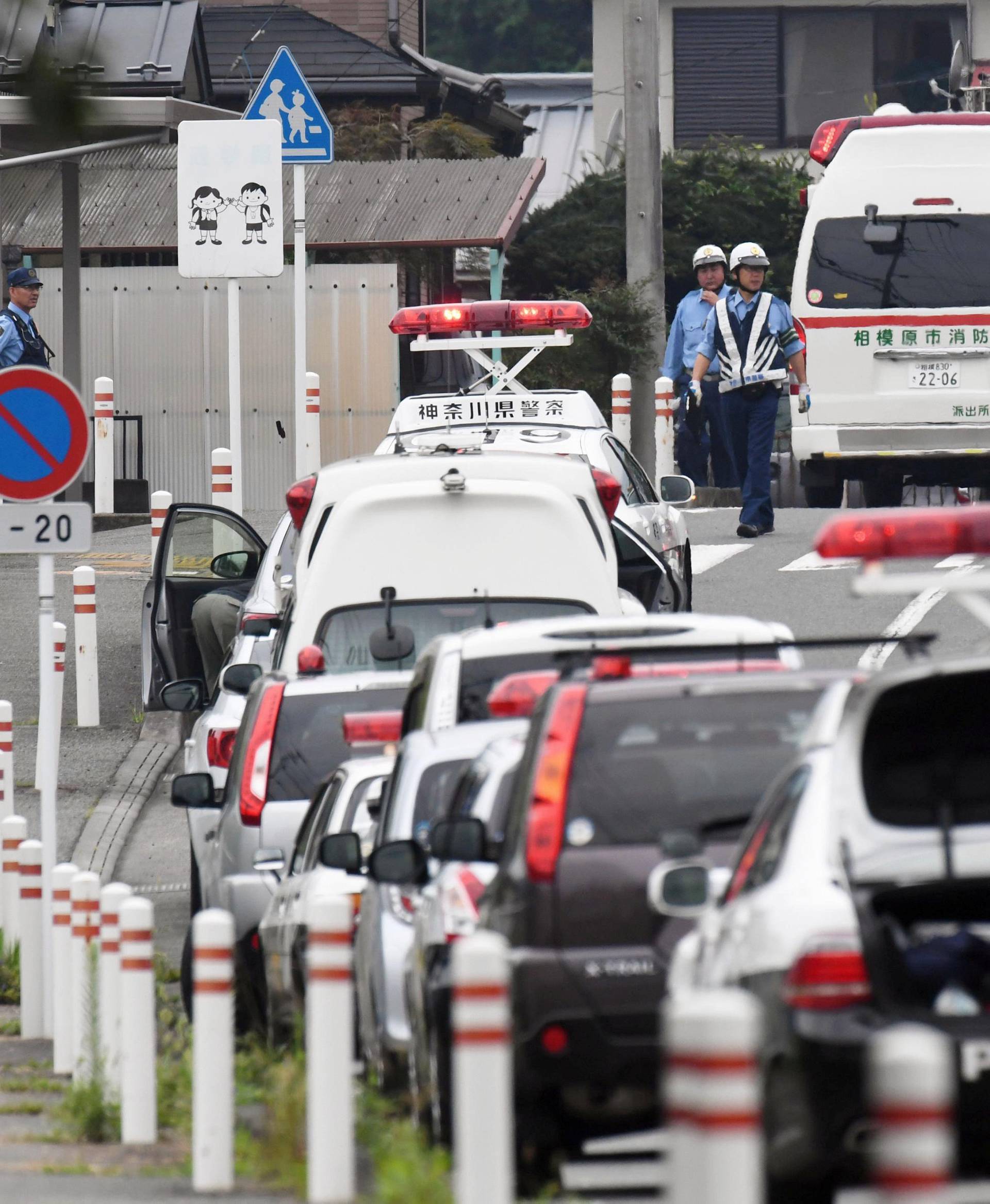 Police officers are seen near a facility for the disabled where at least 19 people were killed and as many as 20 wounded by a knife-wielding man, in Sagamihara