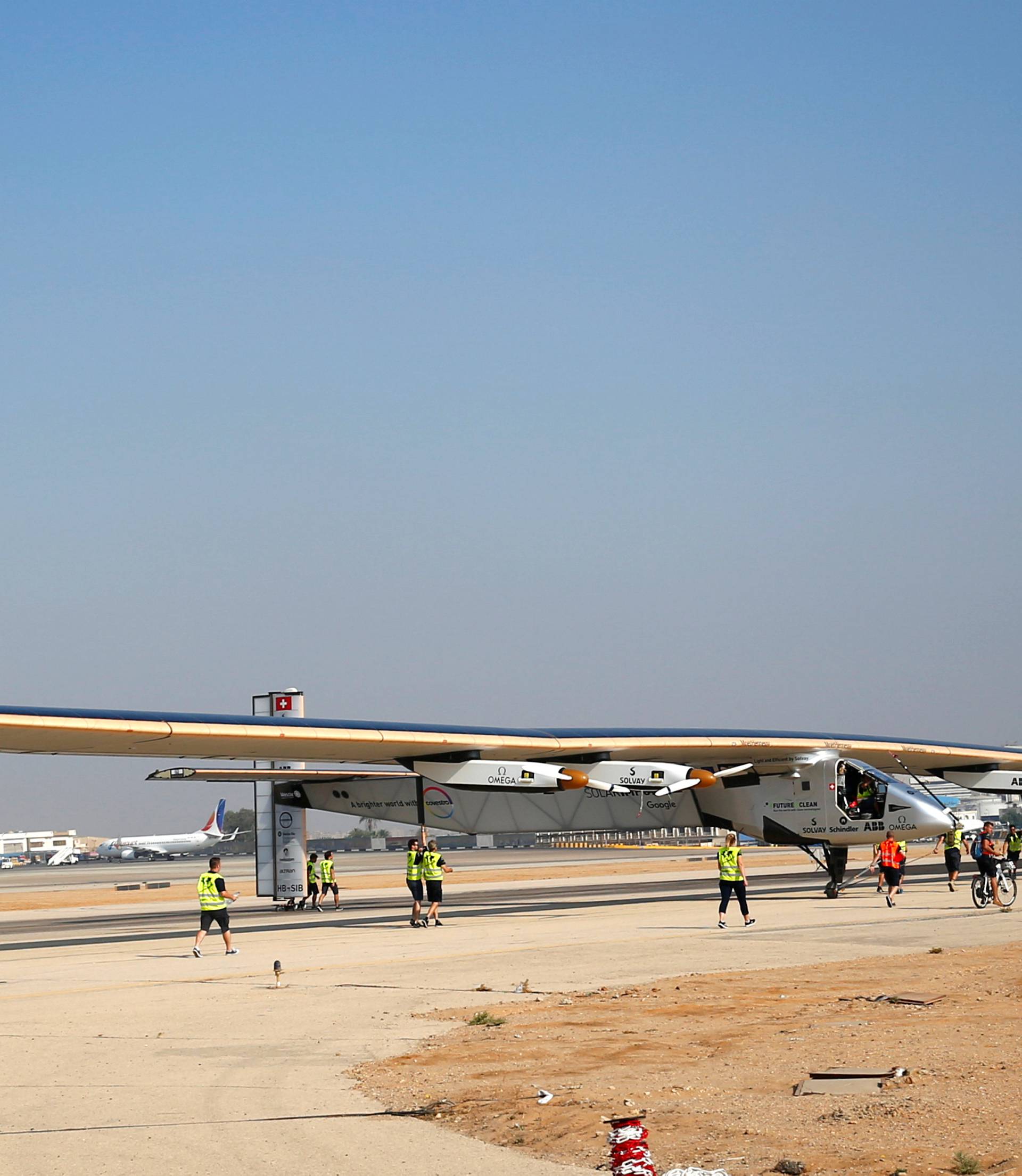 The ground crew of Solar Impulse 2, a solar powered plane, surround the aircraft after it landed at Cairo Airport