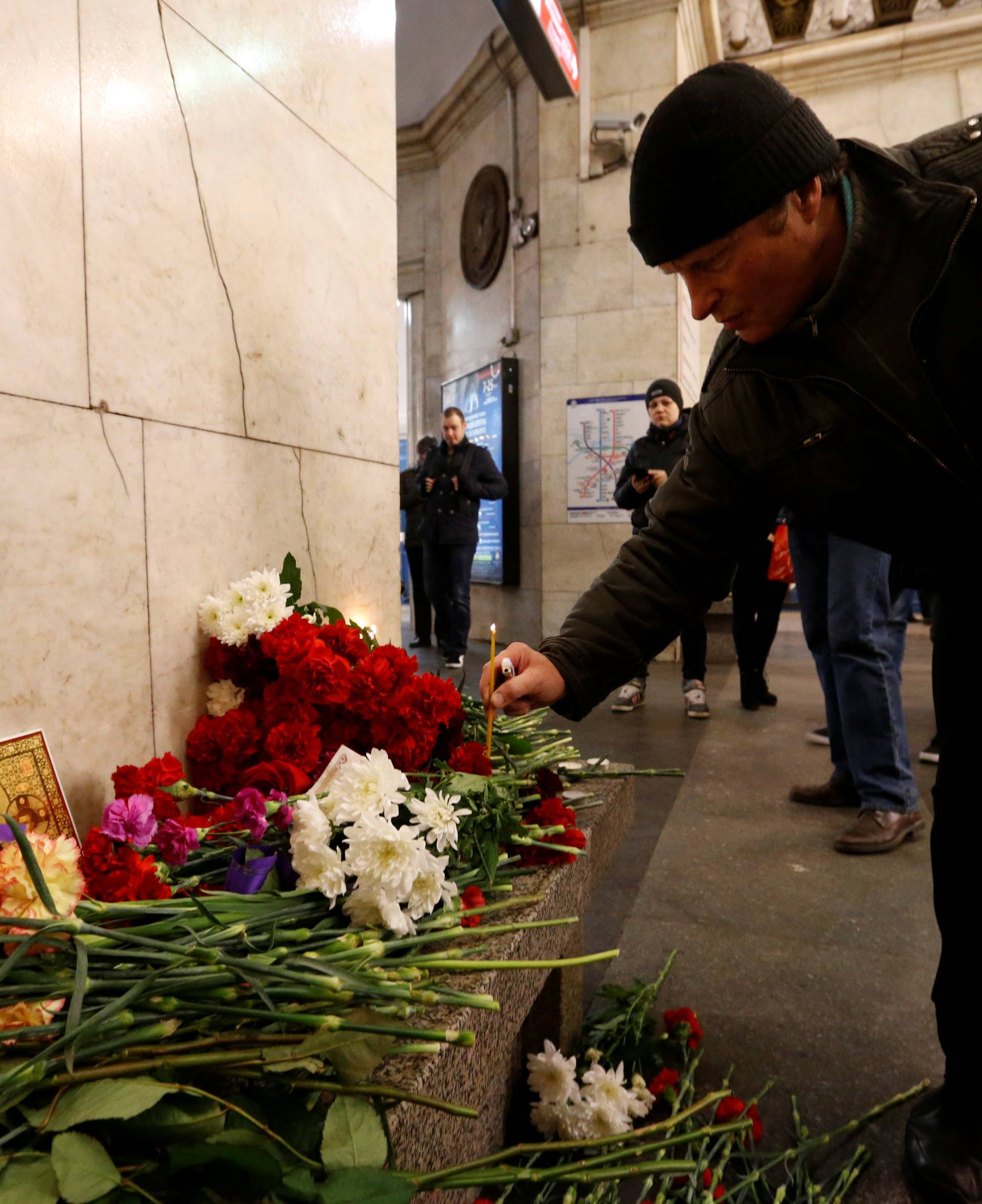 A man leaves a candle in memory of victims of a blast in St.Petersburg metro, at Tekhnologicheskiy institut metro station in St. Petersburg