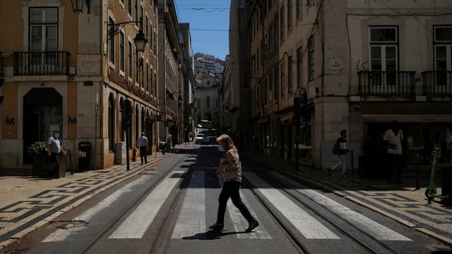 FILE PHOTO: A person wearing a protective mask walks in Lisbon downtown amid the coronavirus disease (COVID-19) pandemic, in Lisbon