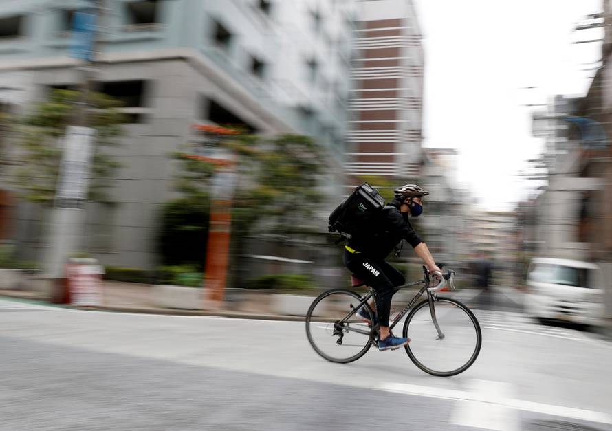 Japan's Olympic fencing medallist Ryo Miyake cycles as he works his part-time job as Uber Eats delivery person as the spread of the coronavirus disease (COVID-19) continues in Tokyo