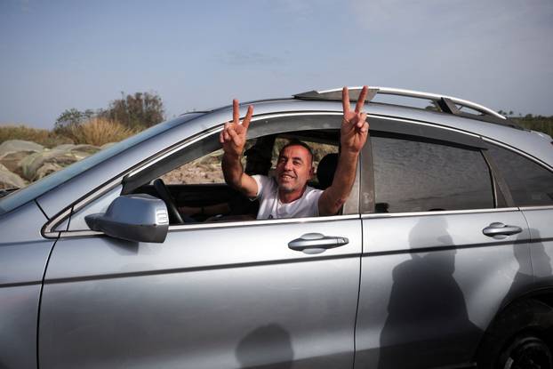 Displaced people cross the bridge linking southern Lebanon to the rest of the country, which was hit earlier in an Israeli strike, in Qasmiyeh