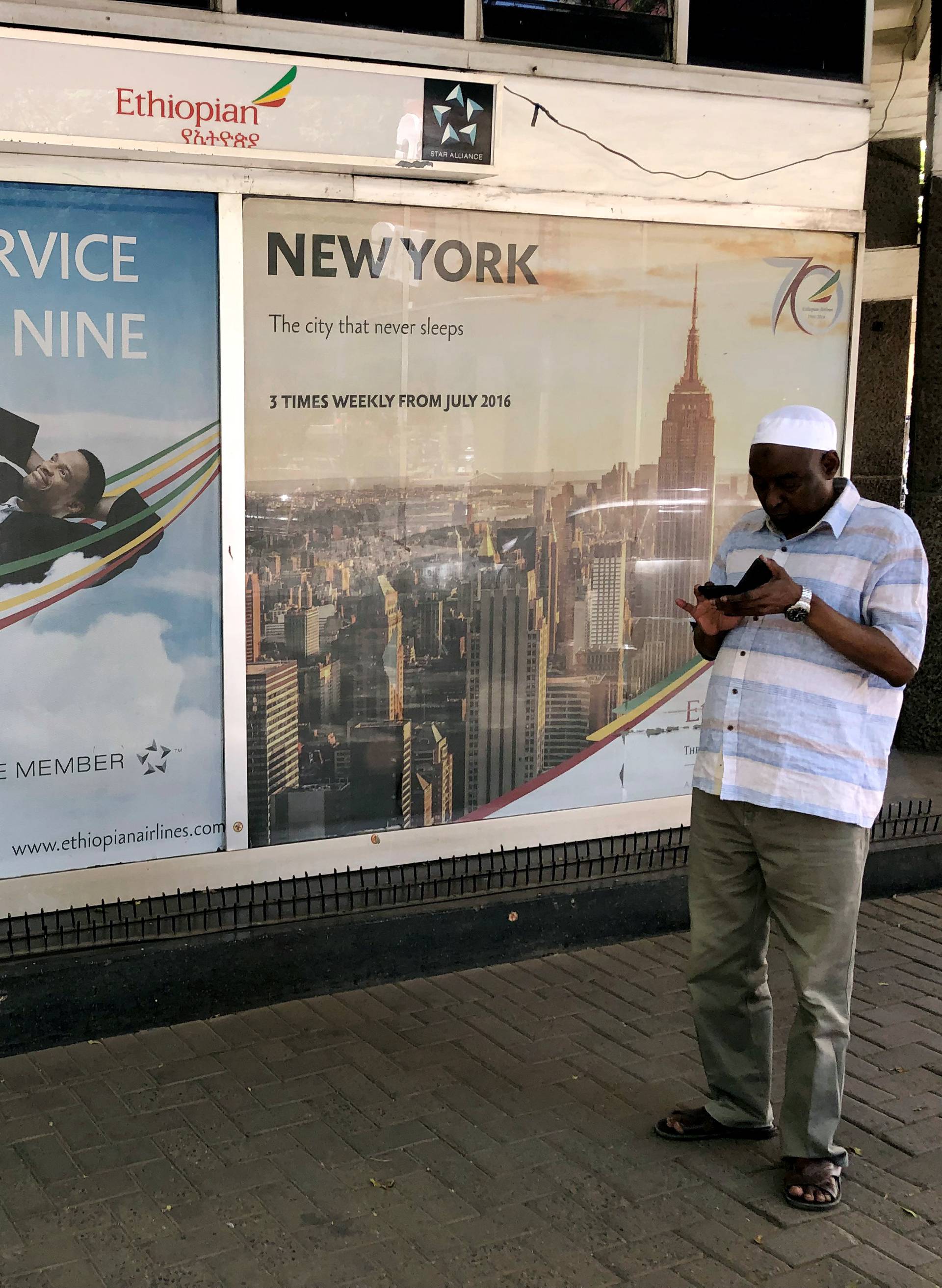 A man looks at his phone outside the Ethiopian Airlines offices in downtown Nairobi