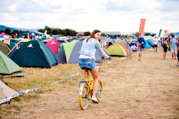 Teenage,Girl,Riding,Yellow,Bike,At,Summer,Music,Festival