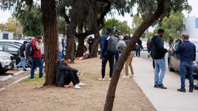 Migrants wait at transit center after being processed and dropped by U.S. Border Patrol