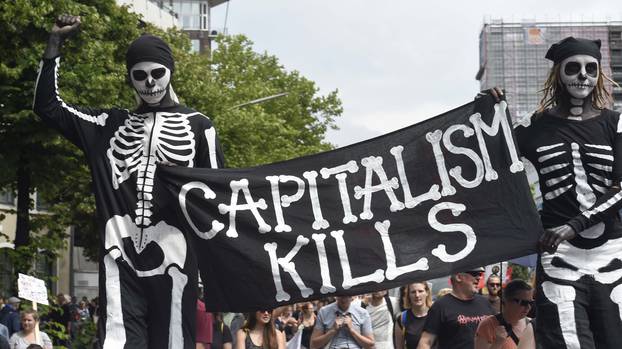 Protesters walk holding a banner during demonstrations at the G20 summit in Hamburg