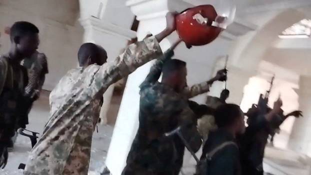 Sudanese army members celebrate inside the presidential palace in Khartoum
