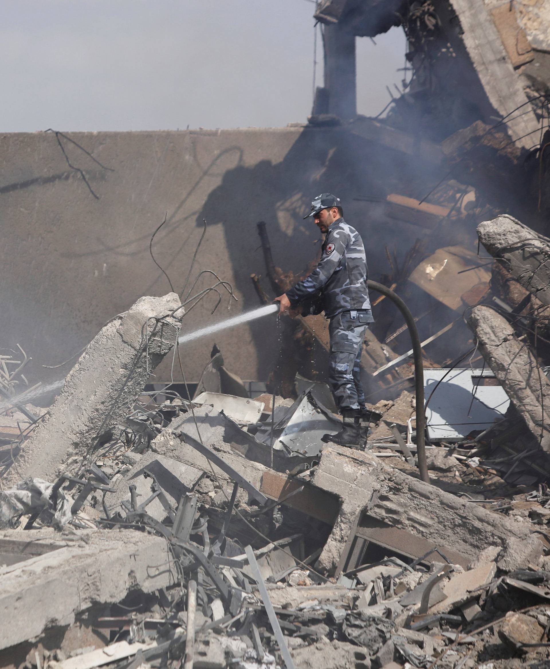 A Syrian firefighter is seen inside the destroyed Scientific Research Centre in Damascus
