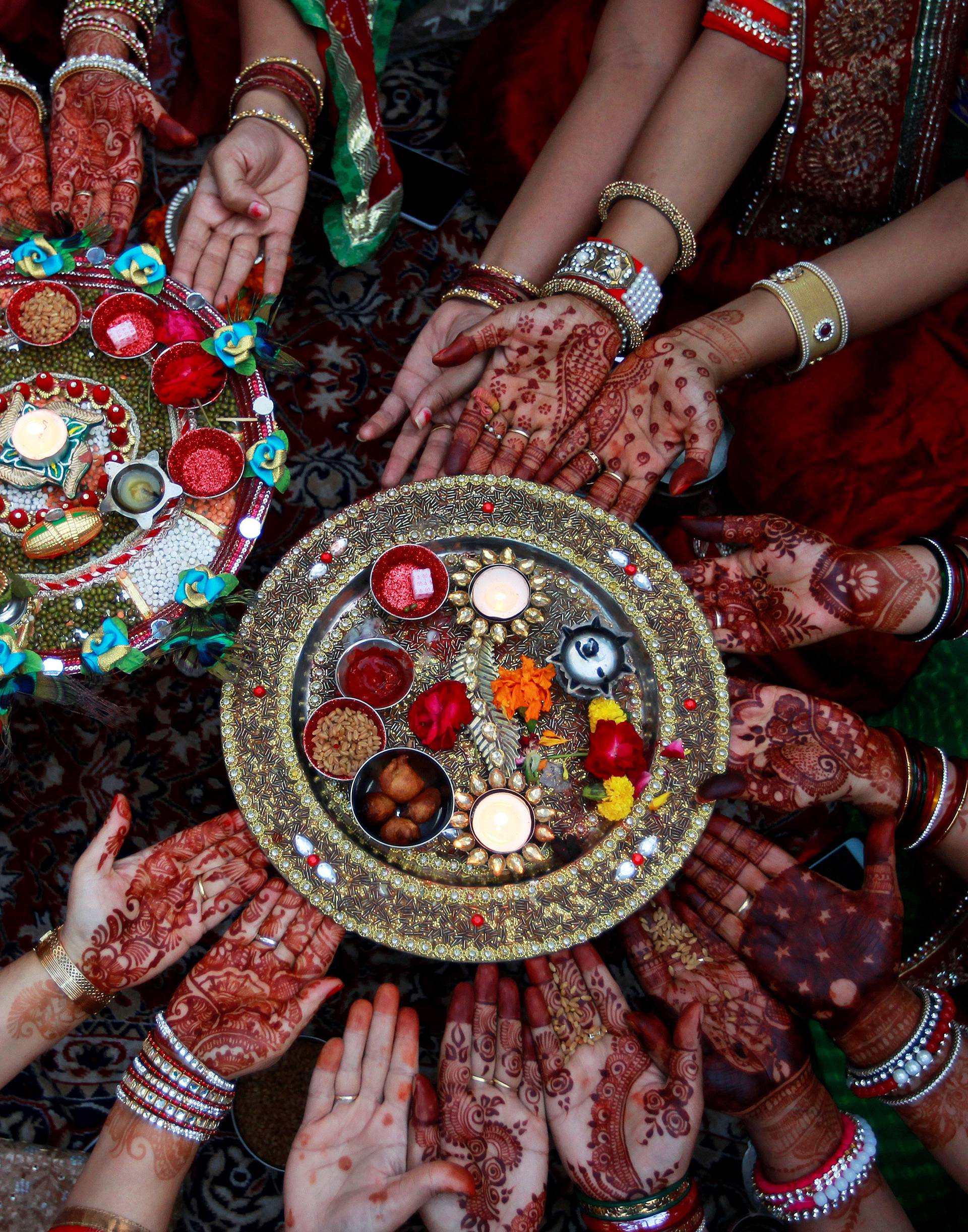 Married women pose for pictures as they perform rituals for the well being of their husbands during the Hindu festival of Karva Chauth in Ahmedabad