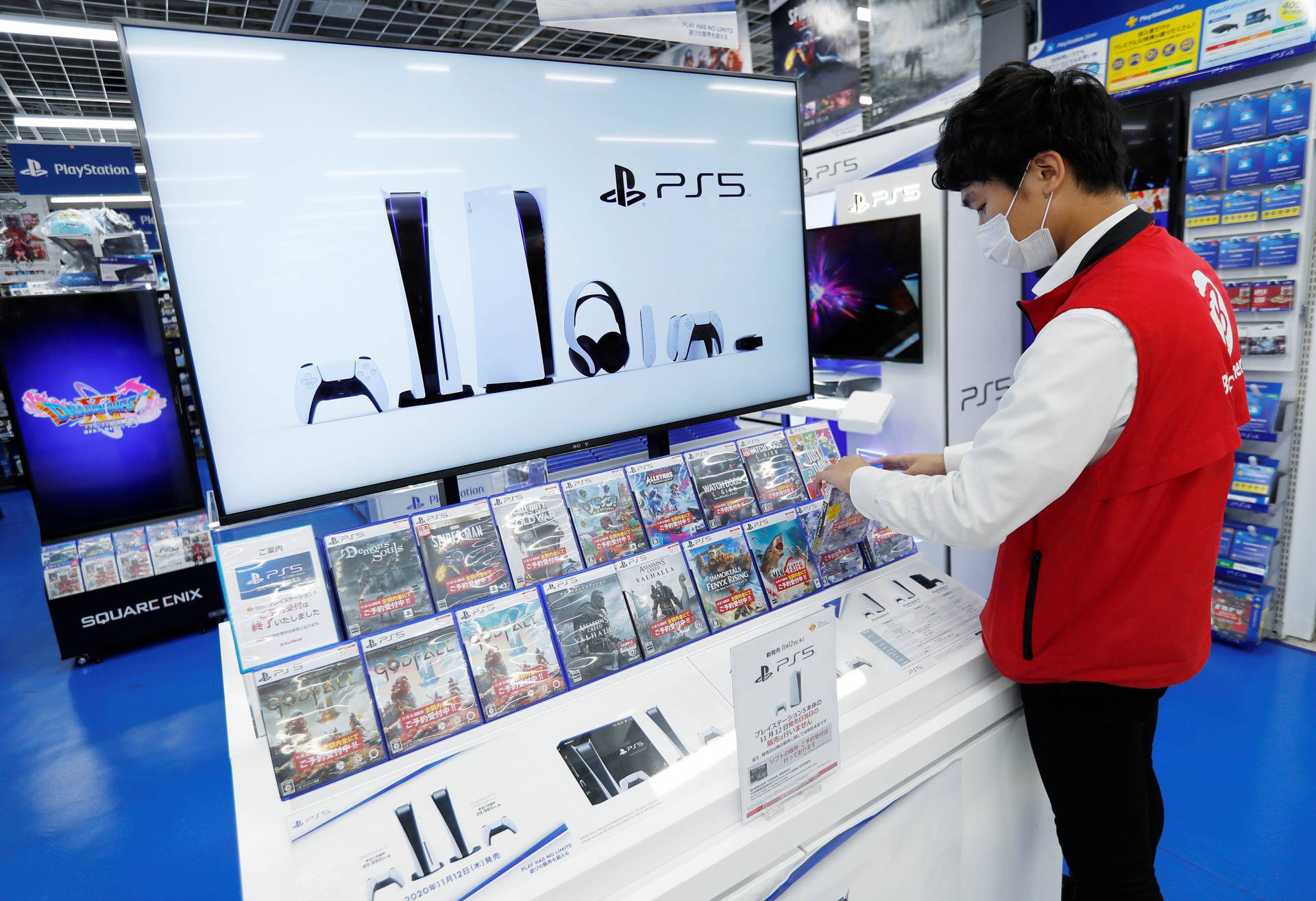 An employee of the consumer electronics retailer chain Bic Camera works at the promotion display of the Sony PlayStation 5 game console and its gaming software, ahead of the game console's official launch, in Tokyo