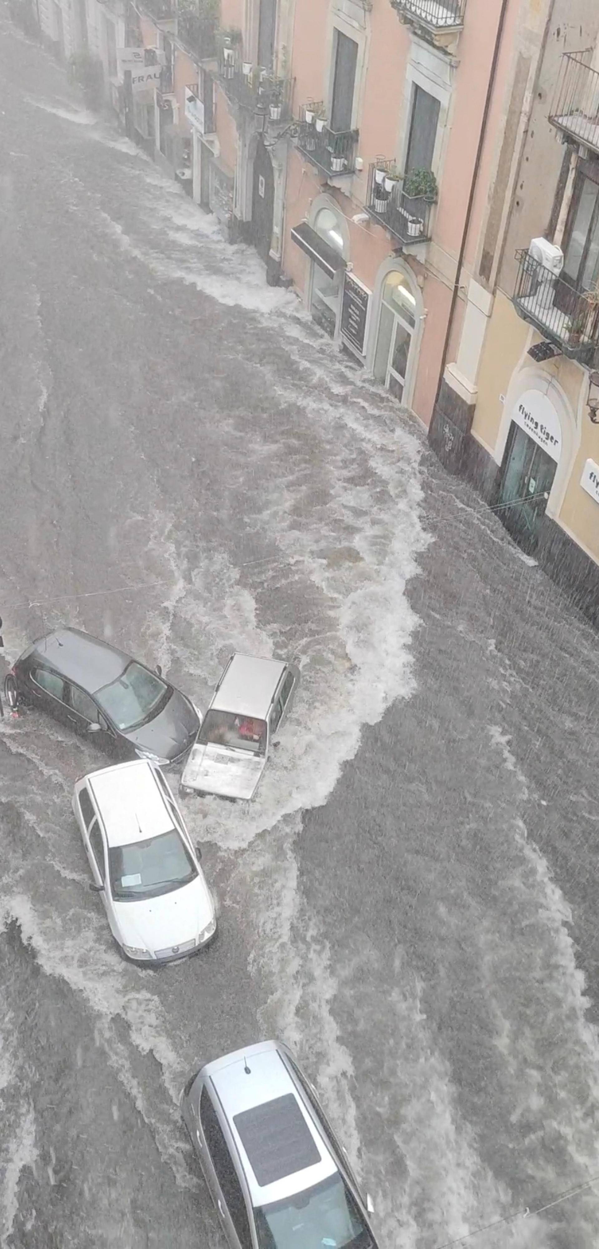 Flood sweeps through a street in the Sicilian city of Catania