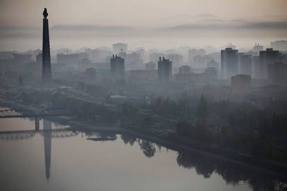 The 170-metre (558-feet) tall Juche Tower is reflected in Taedong River as morning fog blankets Pyongyang