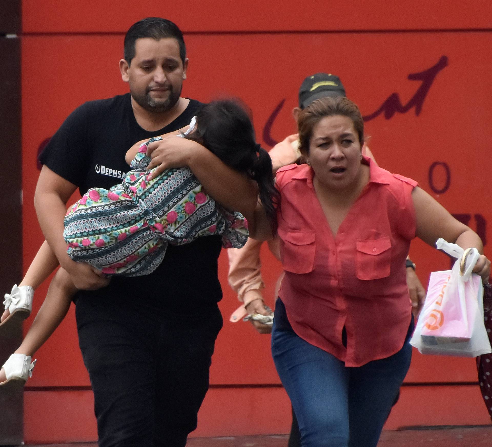 Family runs away from tear gas during clashes between supporters of Nasralla and police during a protest caused by the delayed vote count for the presidential election in San Pedro Sula