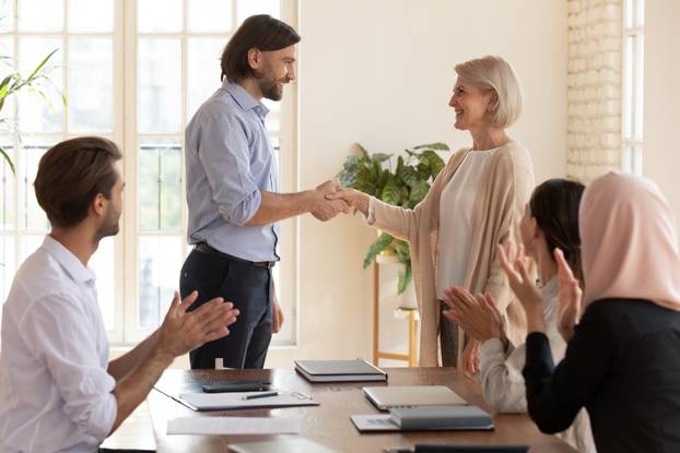 Happy old middle aged female employee get promotion team appreciation