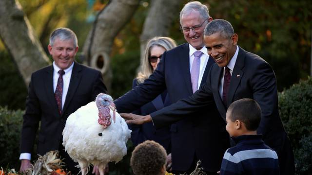 U.S. President Barack Obama attends the pardoning of National Thanksgiving turkey accompanied his nephews Aaron Robinson and Austin Robinson at the Rose Garden of the White House in Washington