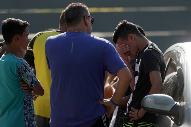 People wait for information at Flamengo training centre after deadly fire in Rio de Janeiro