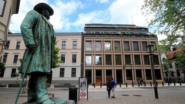 FILE PHOTO: People go about their day near Norway's central bank building in Oslo