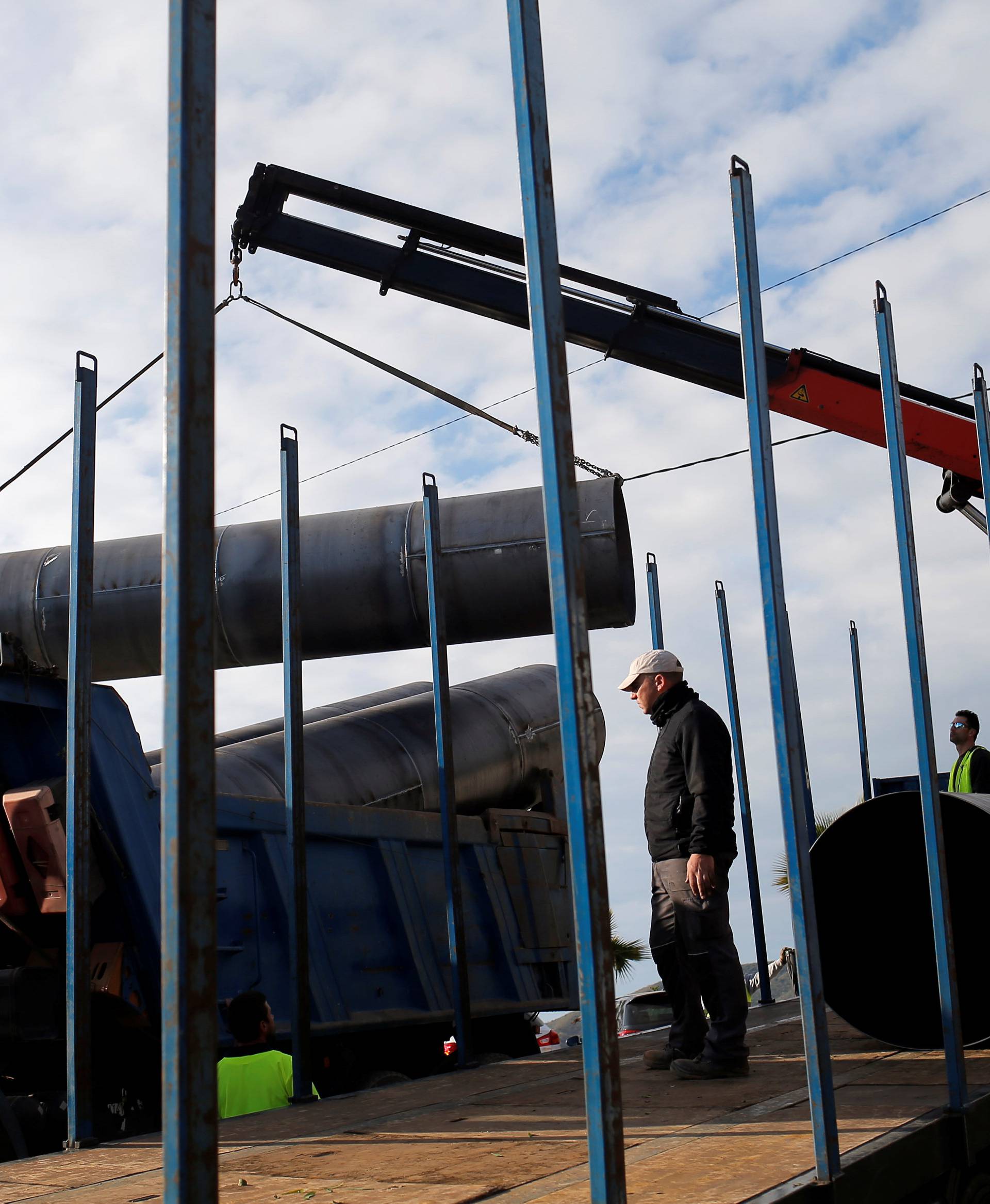 Workers load steels tubes onto a truck, which will be used to protect a deep well, next to the area where Julen, a Spanish two-year-old boy fell into the well four days ago when the family was taking a stroll through a private estate, in Totalan