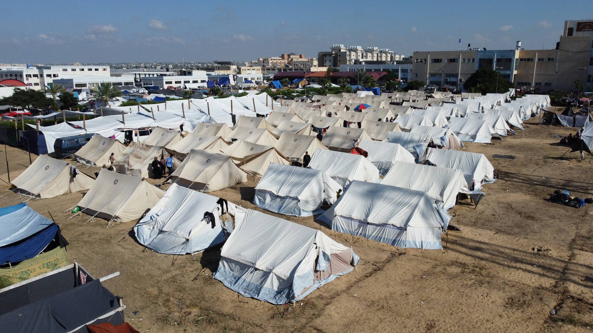 Palestinians, who fled their houses amid Israeli strikes, take shelter in a tent camp at a UN-run centre, in Khan Younis