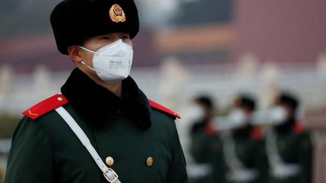 A paramilitary officer wearing a face masks stands guard at the Tiananmen Gate, as the country is hit by an outbreak of the new coronavirus, in Beijing