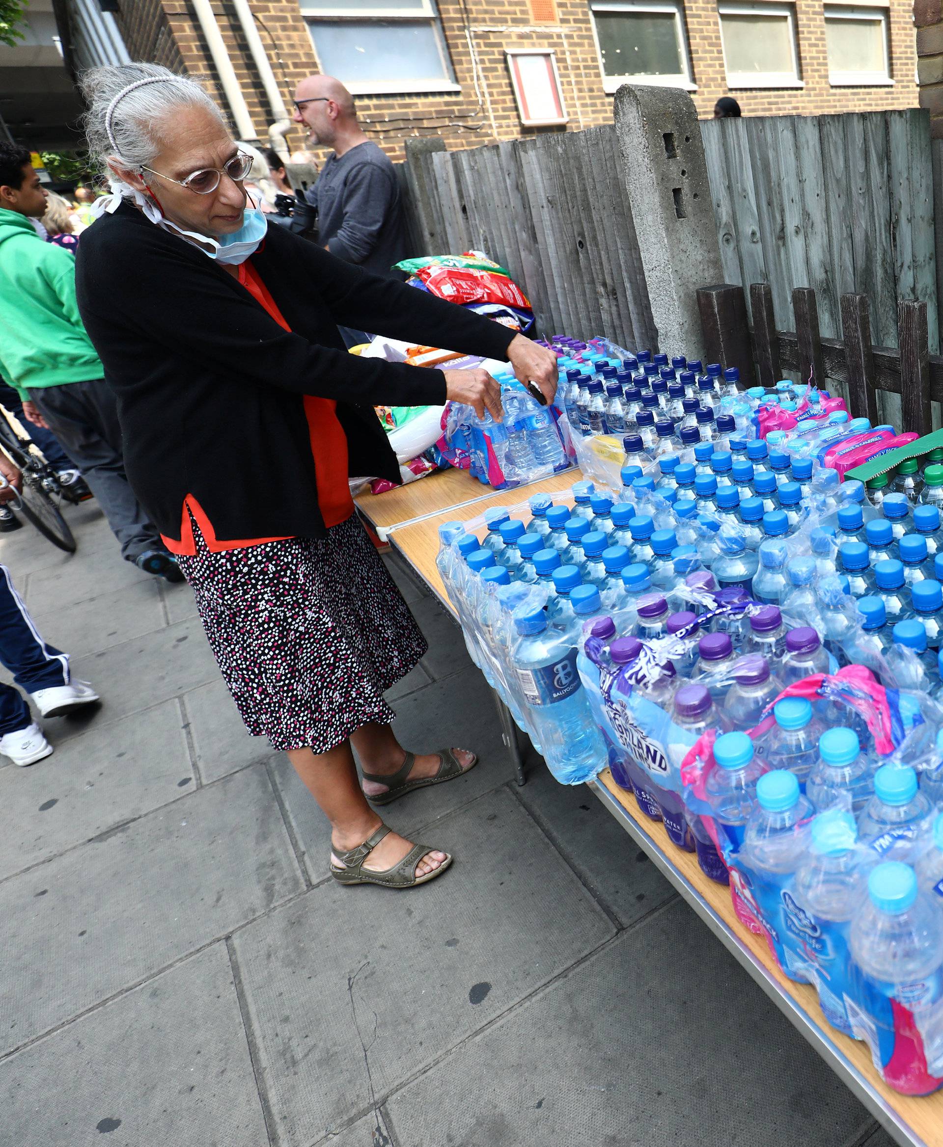 Water and other drinks are laid out near a tower block severely damaged by a serious fire, in north Kensington, West London