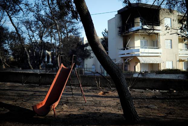 A slide is seen in a burnt playground following a wildfire at the village of Mati, near Athens