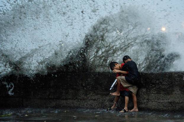 Children play near strong waves amid Super Typhoon Man-yi, in Manila