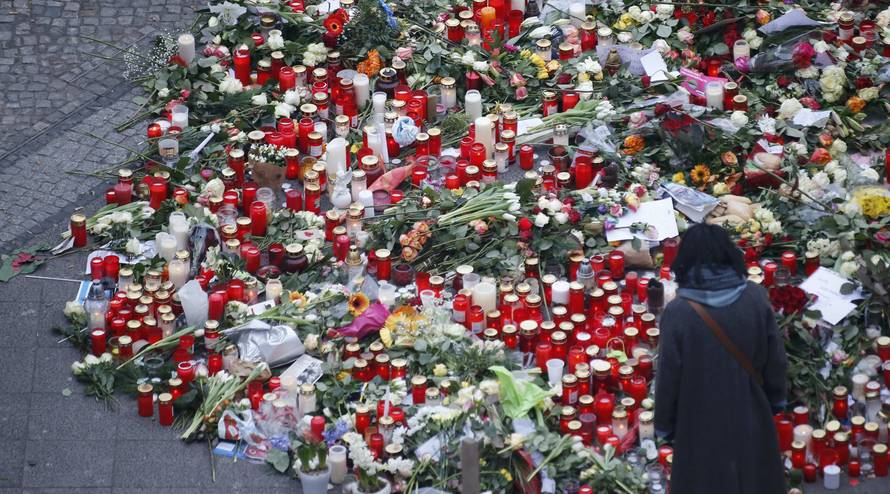 Flowers and candles are placed near the Christmas market in Berlin