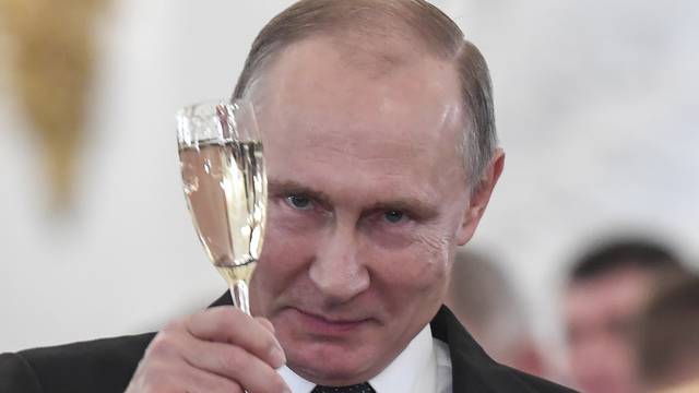 Russian President Vladimir Putin toasts with attendees after a state awards ceremony for military personnel who served in Syria, at the Kremlin in Moscow