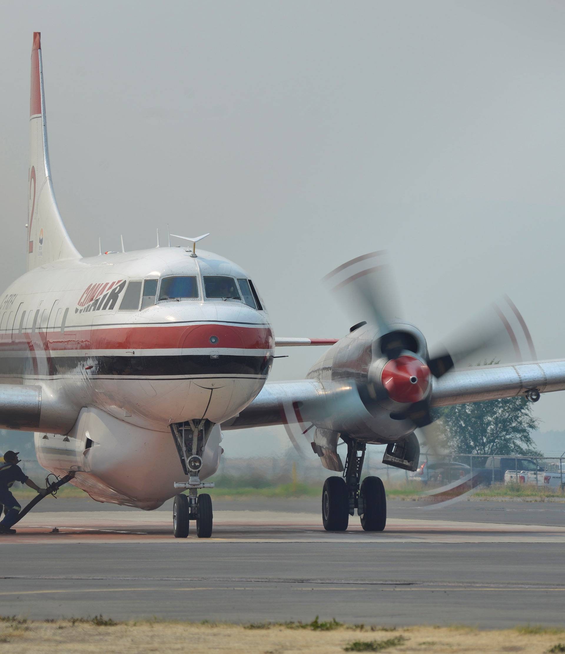A ground crew fills a Conair airtanker with fire retardant at the Provincial Wildfire Coordination Centre at Kamloops Airport