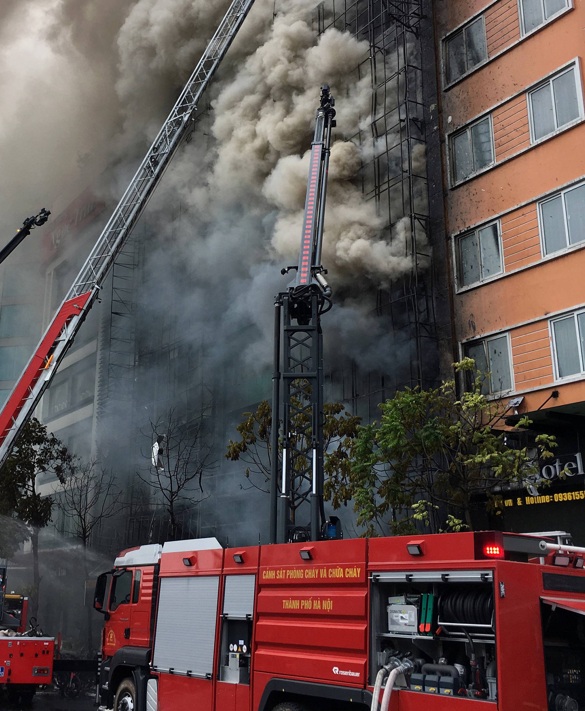 Firefighters work after a fire broke out at a karaoke lounge in Hanoi