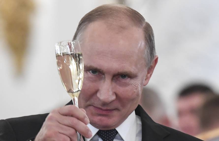 Russian President Vladimir Putin toasts with attendees after a state awards ceremony for military personnel who served in Syria, at the Kremlin in Moscow