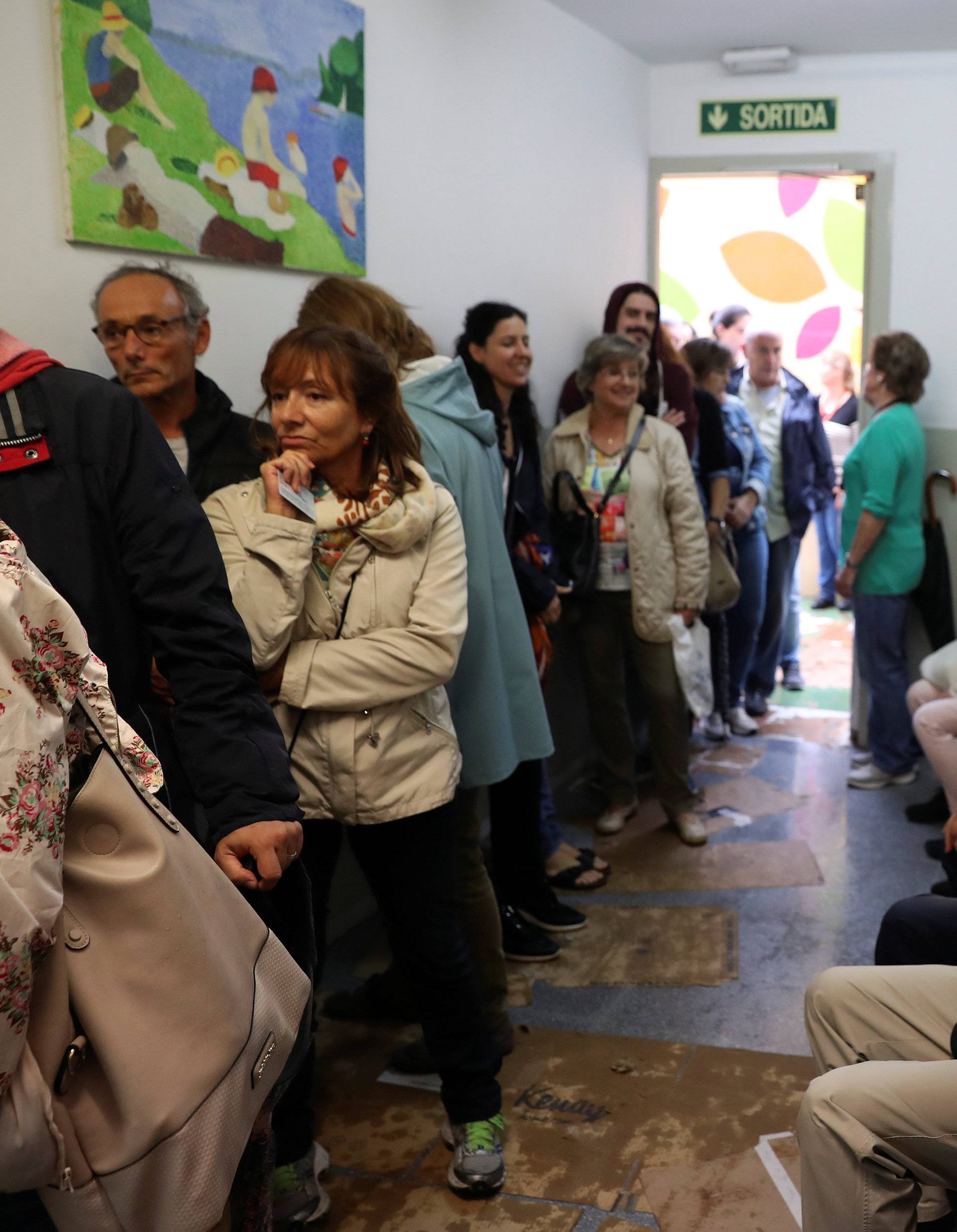 People queue to vote in the banned independence referendum at a polling station in Barcelona