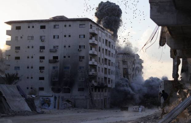 Residential building collapses after an Israeli air strike, in Gaza City