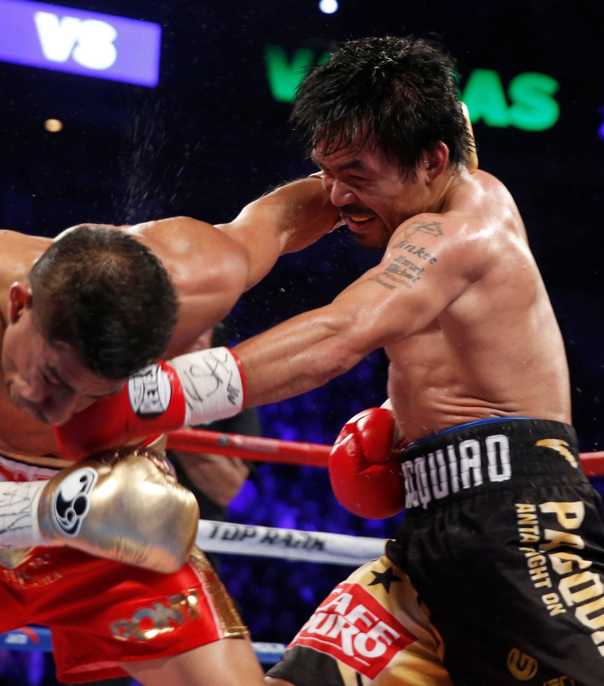 Manny Pacquiao (R) of the Philippines connects with  a punch from WBO welterweight champion Jessie Vargas of Las Vegas during their title fight at the Thomas & Mack Center in Las Vegas