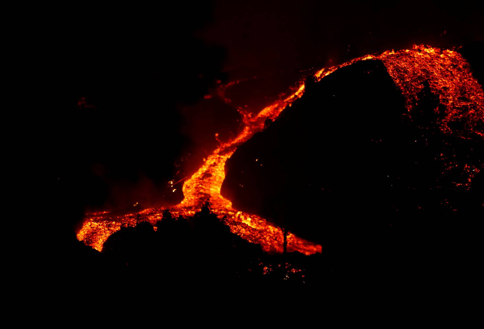 Lava flows downhill following the eruption of a volcano in Spain